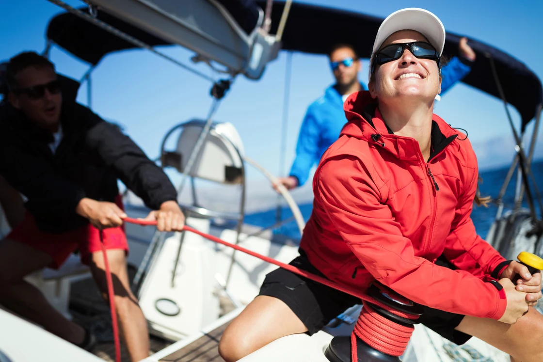 A sailing team working together with ropes and a winch.